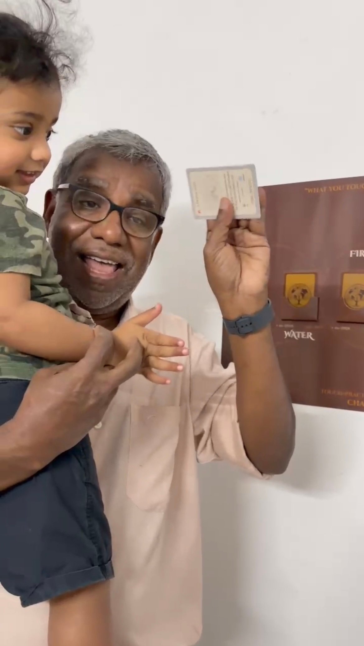 A child placing a card on the NEEYAM wall at home